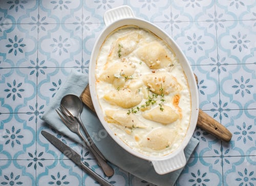 Preview: shells pasta bake in baking dish on dark grey concrete table, horizontal view from above, close-up