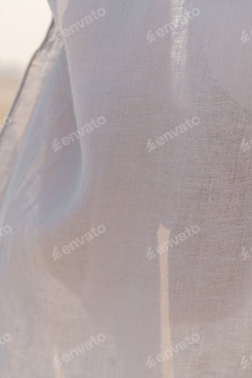 Preview: Legs of a woman through a thin linen clothing