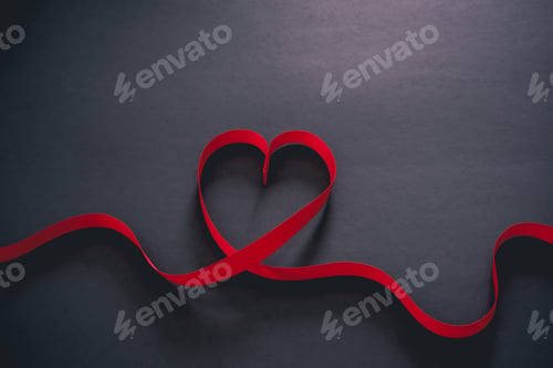 Preview: Red ribbon in the shape of a heart in a black background, Valentine’s Day