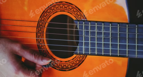 Close-up Playing Acoustic Guitar with a Pick