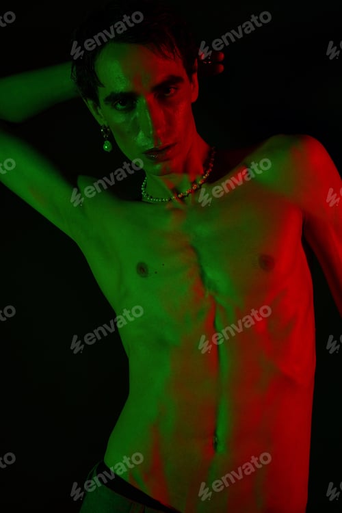 Preview: Stylish man poses dramatically with vibrant lighting in an artistic setting
