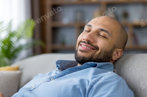 Preview: Young man relaxing with closed eyes on sofa