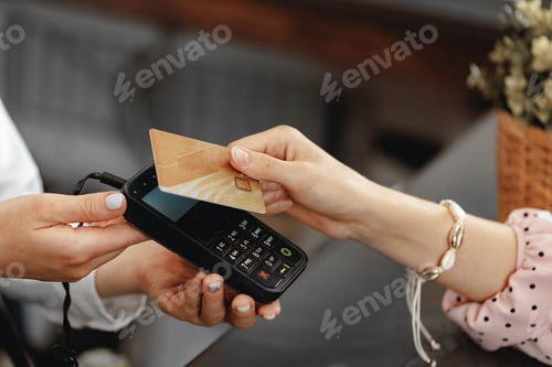 Preview: Close up of hand of customer paying with contactless credit card