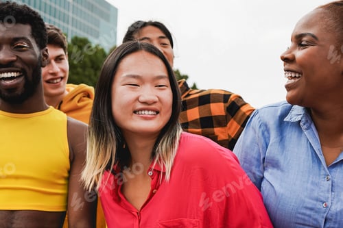 Preview: Group of young multiracial people people having fun together in the city
