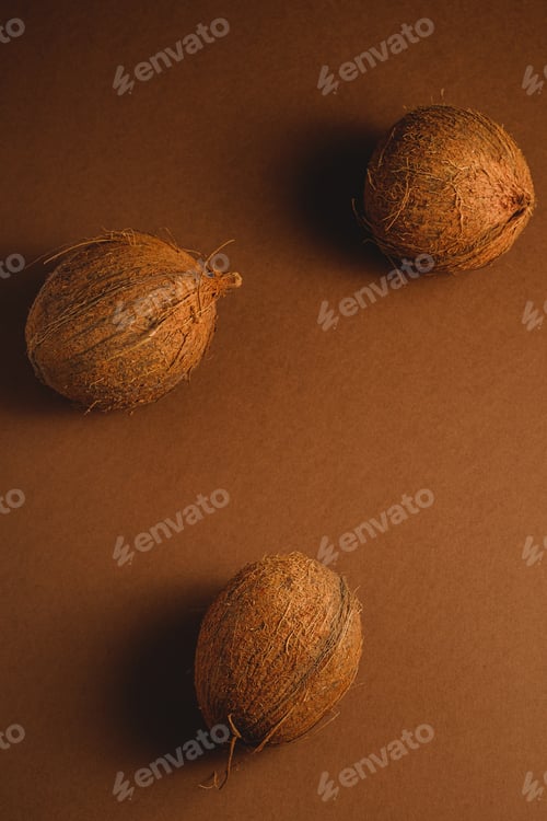 Preview: Three coconut fruits on brown background