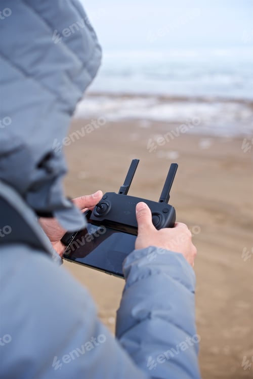 Preview: A young man launches a drone with the remote controller