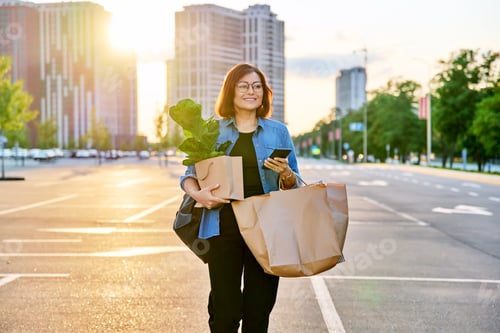 Preview: Urban portrait of middle aged woman with shopping bags in mall parking