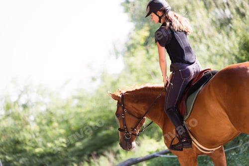 Preview: Portrait of young woman riding horse in countryside