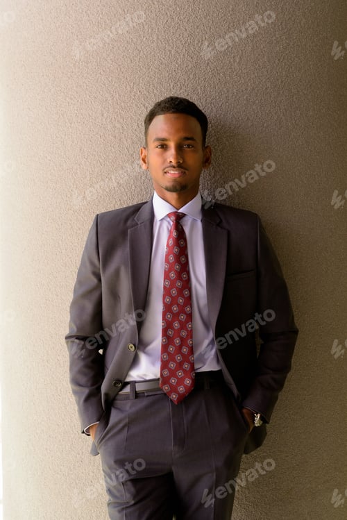 Preview: Portrait of African businessman wearing suit and tie outdoors in city