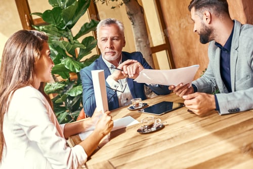 Preview: Business lunch. Three people in the restaurant sitting at table discussing project concentrated