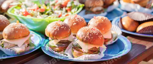 Preview: Buffet table with many mini burgers at outdoors birthday party for children, kids. Catering at weddi