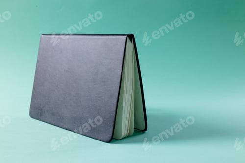 Preview: Close up of black notebook with copy space on green background