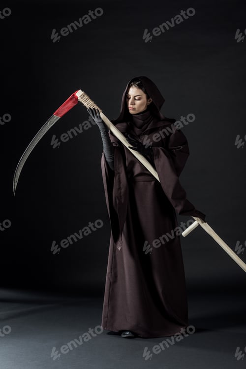 Preview: full length view of pensive woman in death costume holding scythe on black