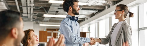 Preview: Smiling female boss leader shaking hand of new team member recruiting him for job on