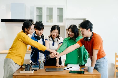 Preview: Teamwork and creativity with young adults collaborating on laptops and tablets in a cozy