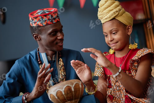 Preview: Black Man and Black Girl Celebrating Kwanzaa by Playing Traditional Drum