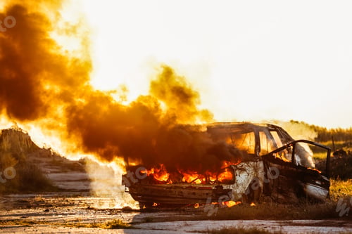 Preview: Car Burning with open flames and sunset in background