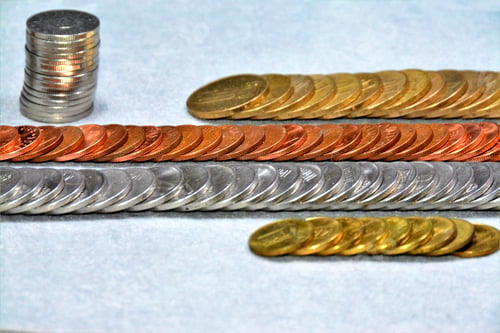 Preview: High angle shot of a variety of coins on a grey surface - concept: monetary system