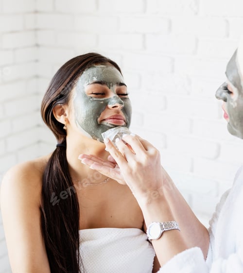 Preview: two beautiful women applying facial mask doing spa procedures