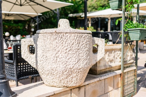 Preview: Rough stone trash bin with lid in outdoor cafe. Rustic design, urban furniture