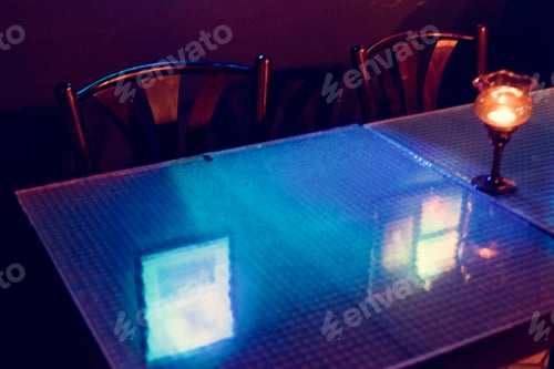 Preview: Reflection of blue light on dining table glass in the restaurant