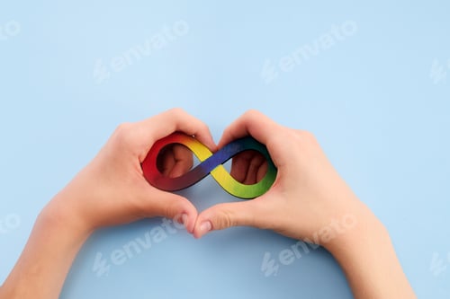 Preview: Autistic boy hands and rainbow eight infinity symbol. Autism awareness day symbol.