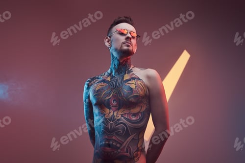 Preview: Tattooed hipster person with naked torso posing in colourful background