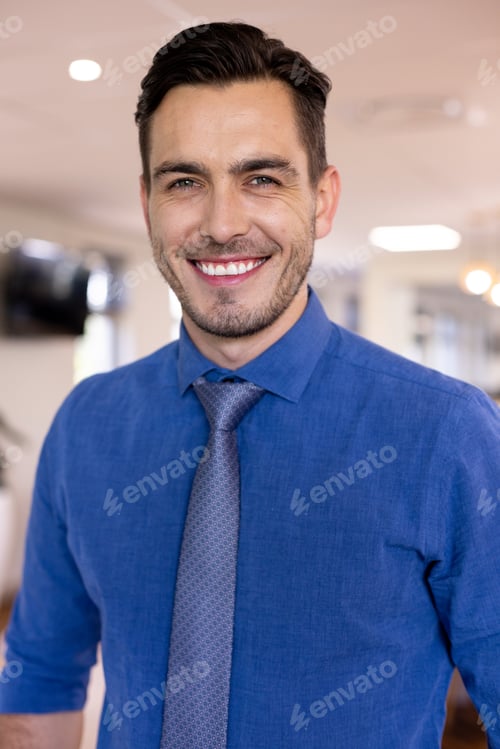Preview: Portrait of happy caucasian businessman wearing blue shirt in modern office