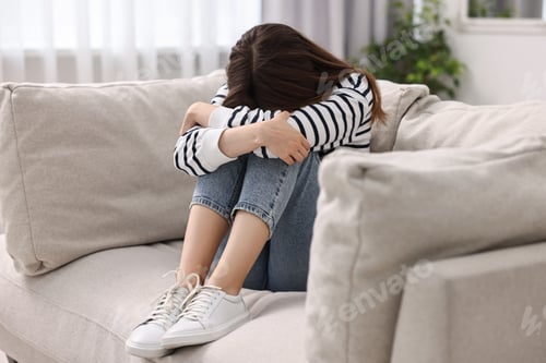 Preview: Loneliness concept. Sad teenage girl on sofa at home