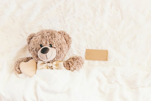 Preview: children's toy sleeps under the blanket. copy space. Selective focus.