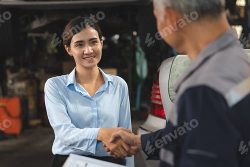 Preview: mechanic technician making handshake deal with business customer at auto car garage service