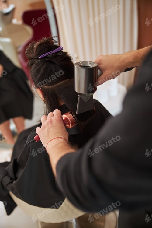 Preview: Woman seated in a salon during a hairstyling procedure