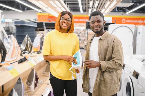 Preview: African american Couple standing in an electronics store choosing an electric iron