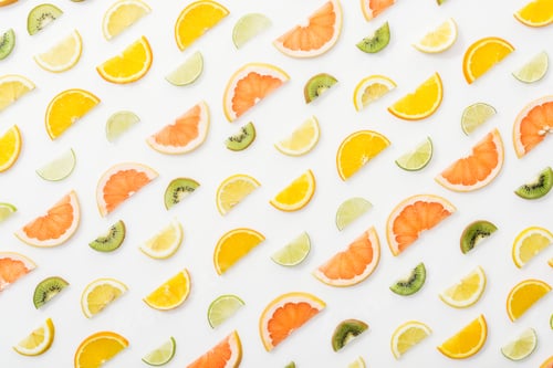 Preview: Flat lay with juicy cut fruits on white surface