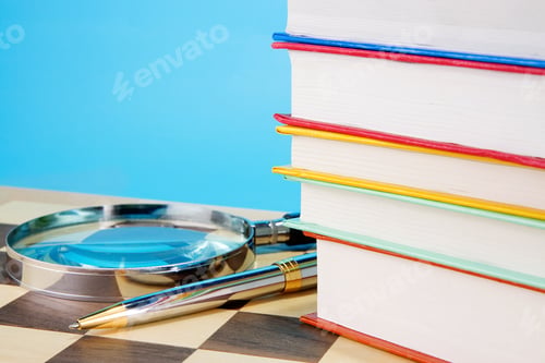 Preview: books, magnifier and pen on chess board
