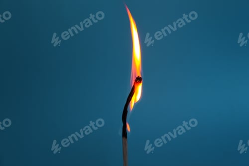 Preview: Burning match stick against blue background