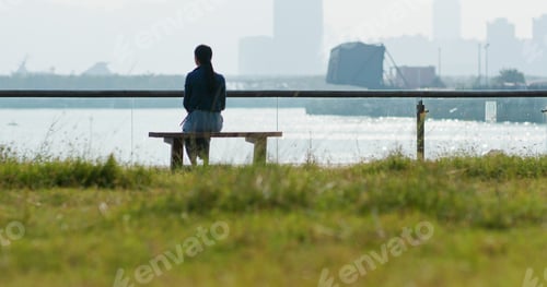 Preview: Woman enjoy the seaside and sitting on the bench