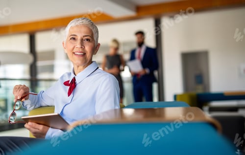 Visualização: Retrato de uma mulher de negócios de sucesso usando tablet digital no escritório