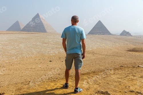 Preview: Man from behind looking at the famous pyramids of giza in egypt, tourist, travel