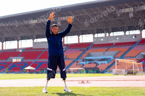 Preview: Asian para-athletes with prosthetic blades sprint on a running track at stadium.