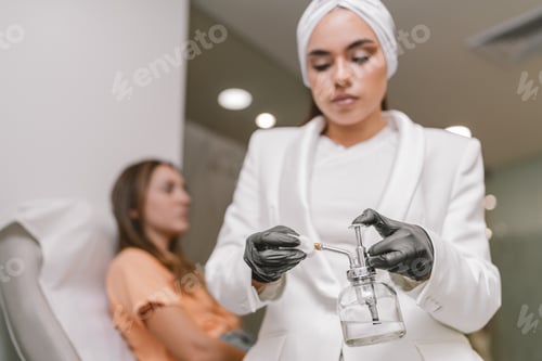 Preview: Beautician doctor soaking a cloth with disinfectant