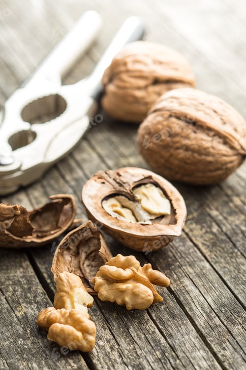 Preview: Cracked dried walnuts and nutcracker.
