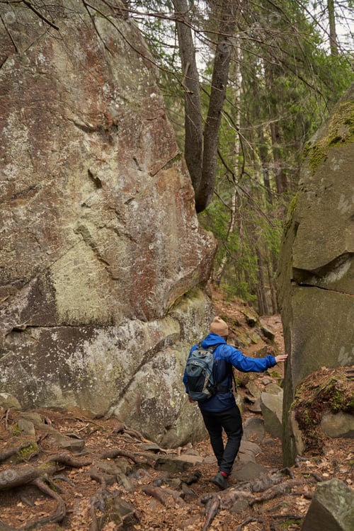 Preview: Behind view of tourist passing between pair of rocks