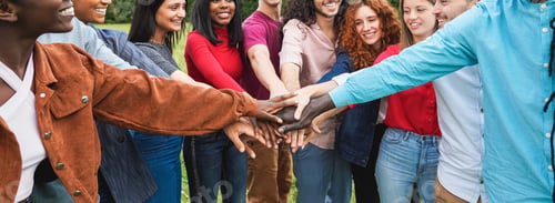 Preview: Young diverse team having fun stacking hands outdoor - Focus on hands