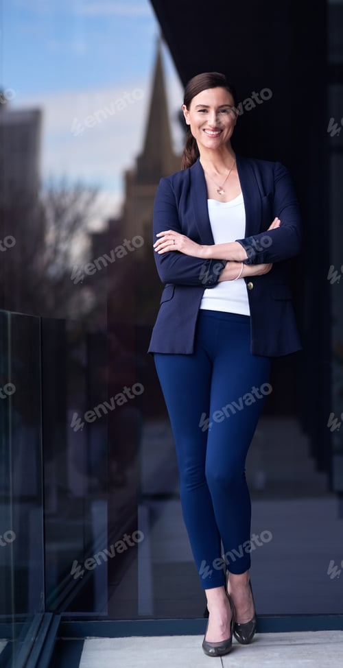 Preview: Portrait of a happy businesswoman standing on a balcony with her arms crossed