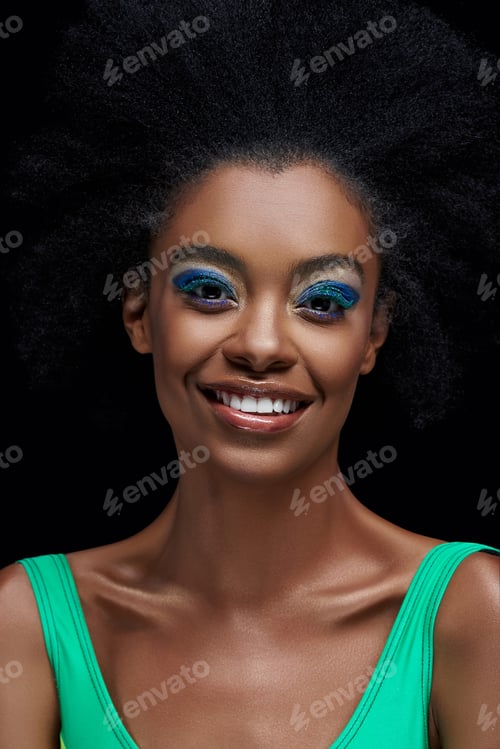 Preview: portrait of smiling african american model with bright blue eyes shadows isolated on black