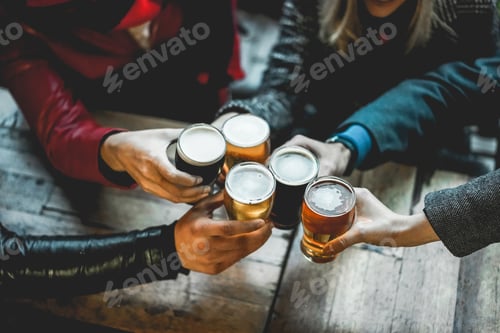 Preview: Young group of people having fun cheering with beer outdoor at bar restaurant