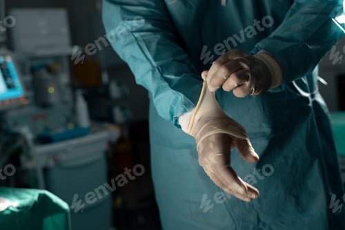 Preview: Midsection of biracial male surgeon wearing surgical gown and gloves in operating theatre