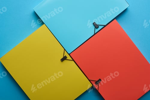 Preview: top view of arranged colorful paper folders on blue