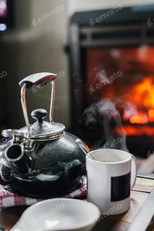 Preview: A home hearth, a lit fire and a table with a teapot and coffee